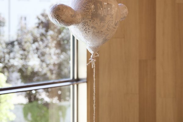 Der als Luftballon dargestellte Comic Handschuh symbolisiert die Leichtigkeit und Freiheit, die wir gegenüber Smartphones und alles, was damit verbunden ist aufbringen. Die sich darauf befindende Collage erinnert an die Bildsprache Sozialer Netzwerke und ihrer aufgeblasenen Bedeutung in unserem täglichen Dasein. Ein dünner Faden zwischen Notwendigkeit und Abhängigkeit. Das Smartphone pendelt, ähnlich einer Uhr, unaufhörlich, ohne dass wir merken, wieviel Zeit dabei verstreicht. Der / die Betrachter*in kann durch diese „Message“ angeregt werden, loszulassen und in ein Buch einzutauchen
