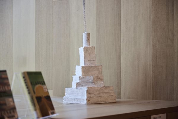 Harald Kastlunger, ein multimedialer Künstler, lebt zwischen Idee und Realität, ständig auf der Suche nach Leidenschaften, die den Menschen antreiben. Das Werk „Turm zu Babel“ präsentiert einen Bücherstapel, der sich nach oben verjüngt und in der Form abstrahiert. Am Ende bleibt eine Leiter, symbolisch für den intellektuellen Aufstieg von der Basis über den Konsum von Büchern hin zu höherem Verständnis. Harald Kastlunger verkörpert in dieser Arbeit die Verbindung zwischen Passion, künstlerischer Kreativität, Wissen und dem Streben nach persönlichem Glück, mahnt durch den Titel jedoch gleichzeitig vor Hochmut und dem Fall.